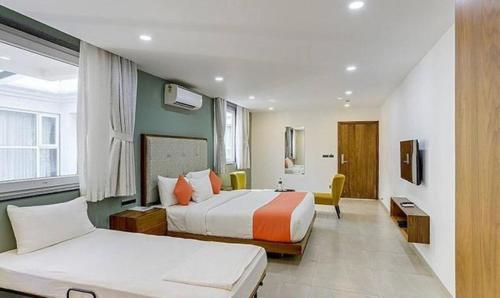 a hotel room with two beds and a couch at Okean De Goa Vagator in Vagator
