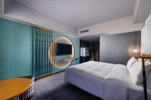 a hotel room with a bed and a round mirror at Mercure Kyoto Station in Kyoto