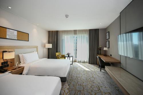 ブバネーシュワルにあるLYFE HOTELのベッド2台とデスクが備わるホテルルームです。