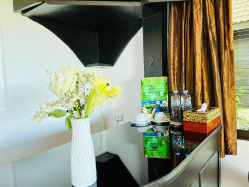 a vase of flowers on a table in a room at Boomerang Village Resort Kata in Kata Beach