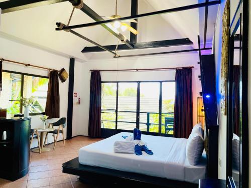 a bedroom with a bed and a large window at Boomerang Village Resort Kata in Kata Beach