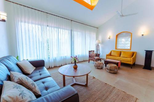 - un salon avec un canapé bleu et une table dans l'établissement Jade430@Candolim beach(3BHK Villa w Private Pool), à Candolim