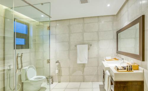 a bathroom with a toilet and a sink and a shower at Virunga Inn Resort & Spa in Kinigi