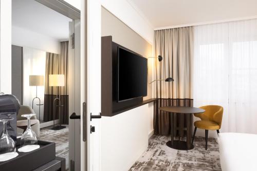 a hotel room with a television and a table at Hilton Heidelberg in Heidelberg
