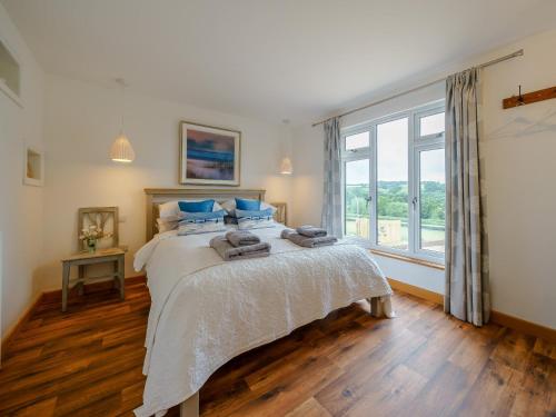 a bedroom with a bed with blue pillows and a window at 2 Bed in Leominster 78637 in Stoke Prior