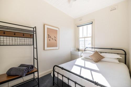 a white bedroom with a bed and a window at The Middle in Adelong