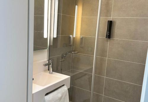 y baño con lavabo y ducha. en B&B HOTEL Cergy Saint-Christophe Gare, en Cergy