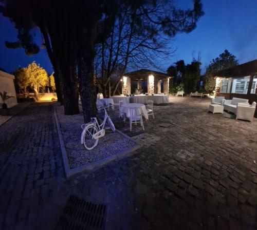 a bike parked under a tree with tables and chairs at Tenuta Oliva in Fisciano