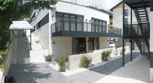 a white house with a staircase and a balcony at Appartementhaus Leeder by Schladming-Appartements in Schladming