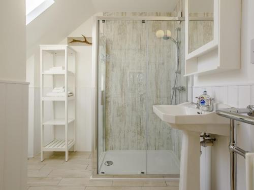 a bathroom with a glass shower and a sink at 4 Bed in The Cairngorms 80298 in Knockandhu