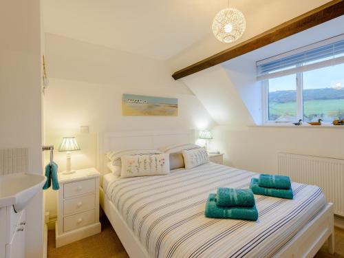 a bedroom with a bed and a sink and a window at 2 Bed in Lulworth Cove DC028 in West Lulworth
