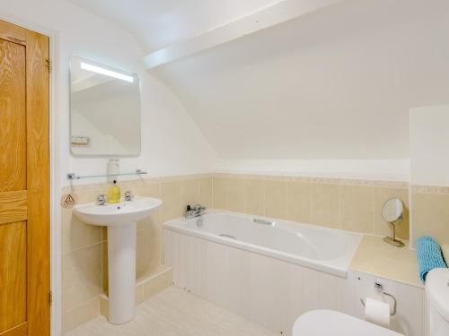 a bathroom with a tub and a sink and a toilet at 2 Bed in Lulworth Cove DC028 in West Lulworth