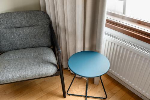 a chair and a blue table next to a window at Original Sokos Hotel Tapiola Garden Espoo in Espoo