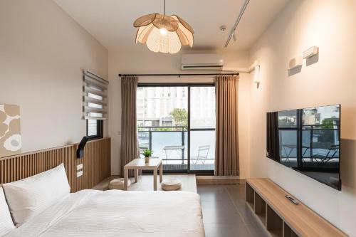 1 dormitorio con 1 cama y TV de pantalla plana en Chunns Inn, en Hengchun