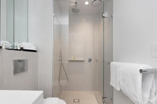 a bathroom with a shower with a toilet and a sink at City Lookout with Amenities in Melbourne
