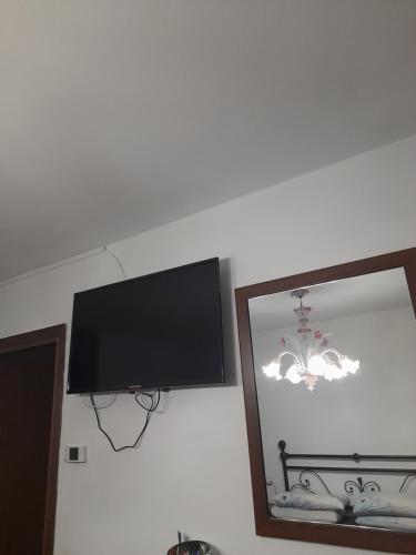 a flat screen tv on a wall next to a mirror at Beb san giorgio in Volpino