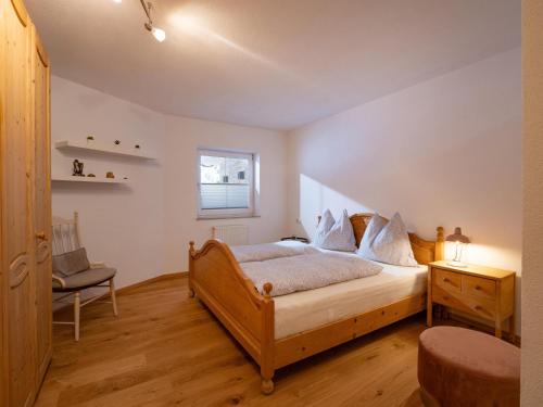 1 dormitorio con cama de madera y silla en Relax Inn en Angerberg