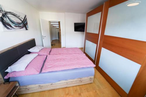 a bedroom with a bed with red and white sheets at Schlafgut Küssler - 70m vom City Express in Zell am See