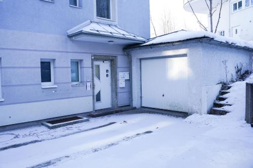 a house with a garage in the snow at Schlafgut Küssler - 70m vom City Express in Zell am See
