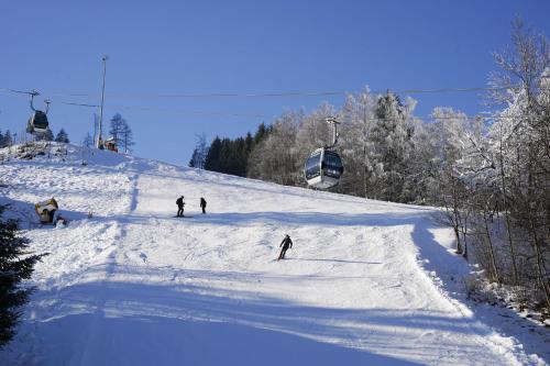 a group of people skiing down a snow covered slope at Schlafgut Küssler - 70m vom City Express in Zell am See