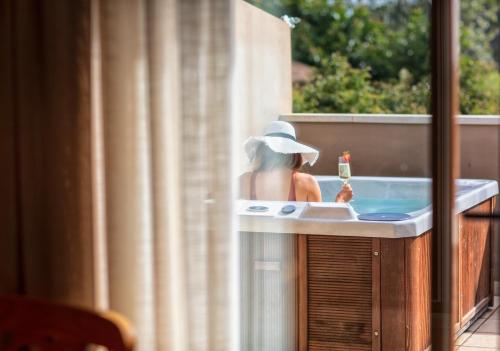 a woman sitting in a bath tub with a drink at Hotel Swiss Moraira in Moraira