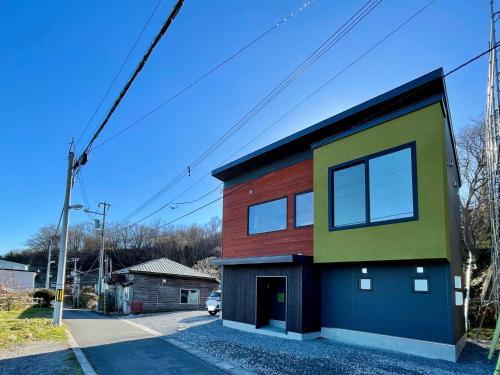 a house with a colorful facade on a street at Hakodate As time flies -Sauna&Villa- 函館 時のたつままに in Hakodate