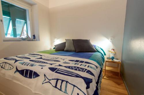 a bedroom with a bed with a fish blanket at La Calata - Monolocale in Portoferraio