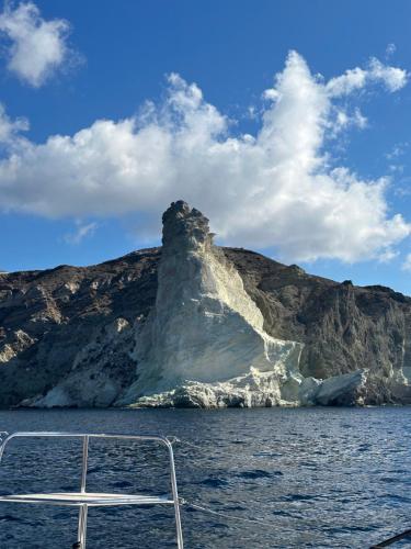 an iceberg in the water with a boat in the foreground at Villa G in Mesaria