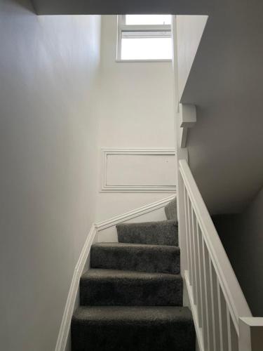 a stairway with a stair case and a window at Luxury en-suite double bedroom Stratford E15 in London