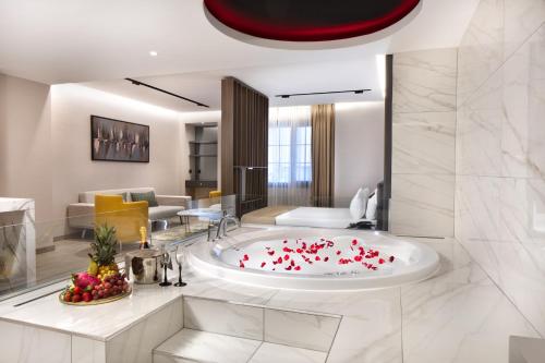 baño con bañera llena de corazones rojos en Nish Palace Beşiktaş en Estambul