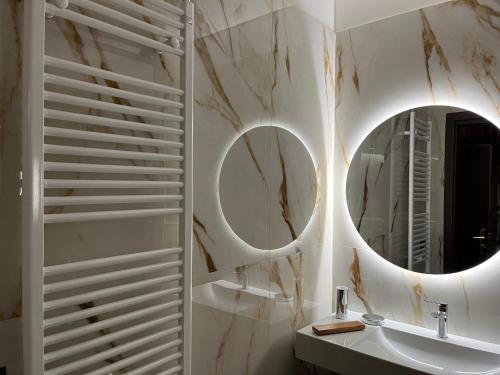 La salle de bains est pourvue de 2 miroirs et d'un lavabo. dans l'établissement Hotel Iris, à Roccaraso