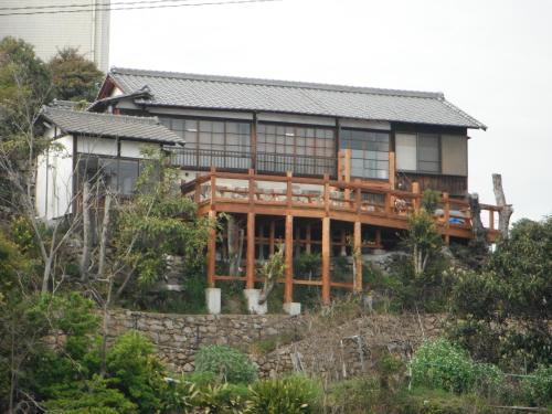 a house on top of a hill at 城跡石垣上の絶景古民家宿 鞆城茶屋庵 in Tomo