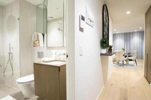 a bathroom with a toilet and a sink and a table at The Cosmopolitan Crown in Melbourne