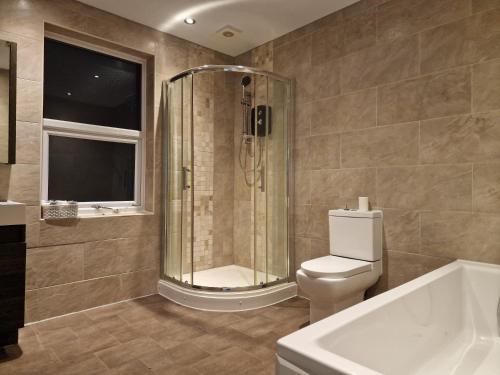 a bathroom with a shower and a toilet and a tub at ArklesFCLiverpool in Liverpool