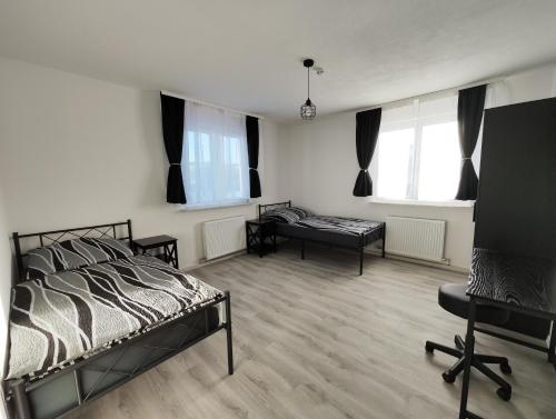 a bedroom with a bed and a chair and windows at Silverstar in Sindelfingen