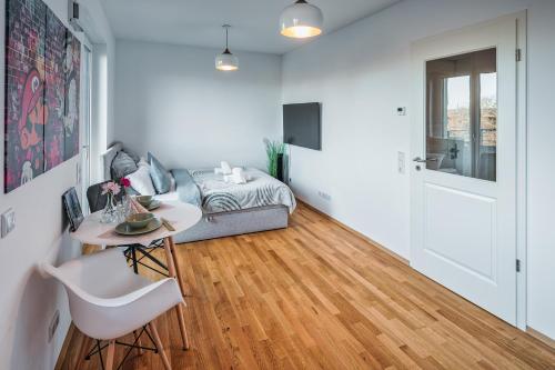 a living room with a table and a bed at Nagelneues Studio in der Hafencity an der Elbe in Dresden