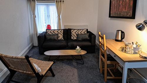 a living room with a couch and a table at The Old Vicarage in Flore