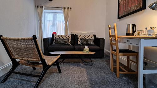 a living room with a couch and a table and chairs at The Old Vicarage in Flore