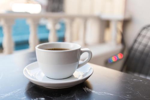 a cup of coffee on a plate on a table at Hotel Queens Land in Istanbul