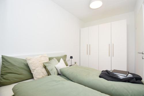 ein Wohnzimmer mit einer großen grünen Couch in der Unterkunft Ferienwohnung in Hard am Bodensee in Hard