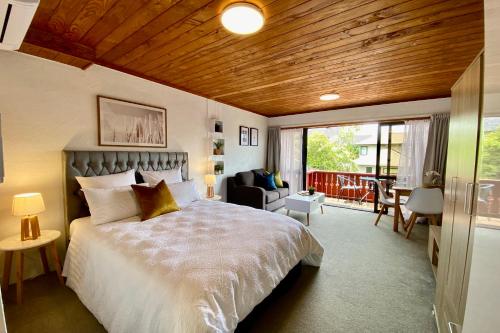 1 dormitorio con 1 cama grande y balcón en The Swiss Chalet Holiday Apartment 4, Bay of Islands en Paihia