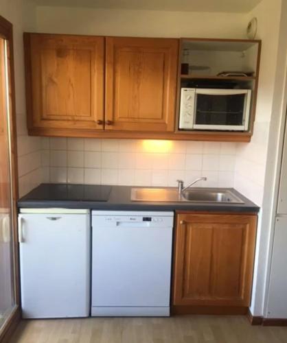 une cuisine avec des appareils électroménagers blancs et des armoires en bois dans l'établissement Apartment with 6 bed close to the slopes, à Saint-Étienne-en-Dévoluy