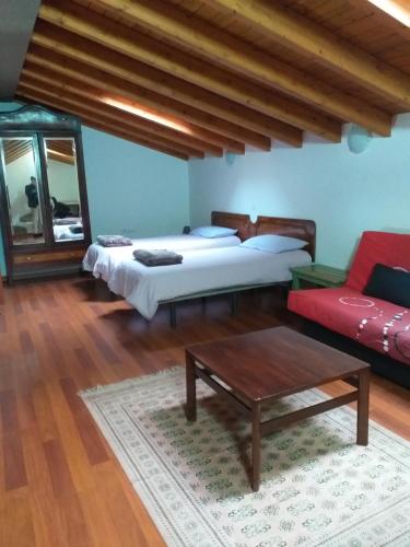 a bedroom with two beds and a coffee table at Casa Rural Carmita in Vega de San Mateo