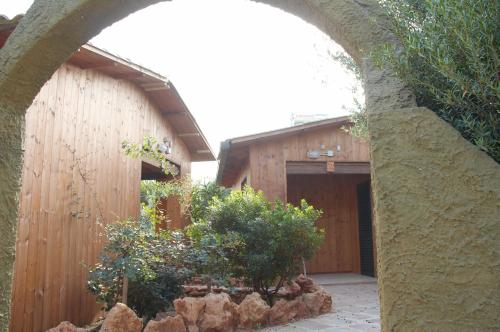 an archway leading to a house with a garage at Villaggio Camping Torre Del Porticciolo in Porto Conte