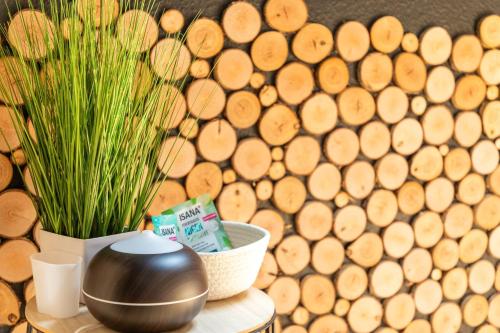 a table with a pot and a plant next to a pile of wood at Wellness-Ferienwohnung Strandurlaub Baabe in Baabe