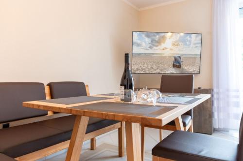 a dining room with a table with a bottle of wine at Wellness-Ferienwohnung Strandurlaub Baabe in Baabe