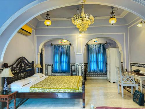 a bedroom with a bed and a chandelier at Saba Haveli in Jaipur