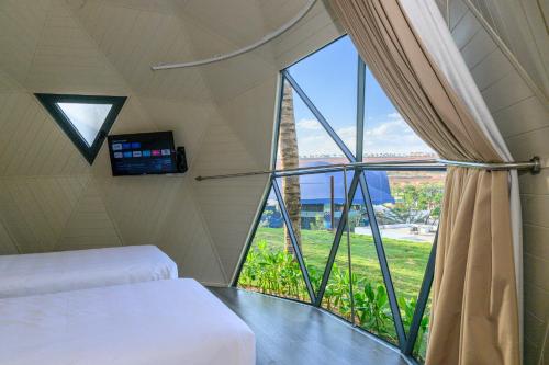 a room with a bed and a large window at Wonderland Resort Phan Thiet in Phan Thiet