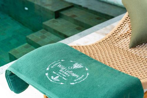 a green book sitting on top of a table at Wild Cottages Elephant Sanctuary Resort in Amphoe Koh Samui