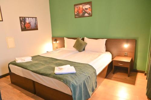 a bedroom with a bed with two towels on it at Hotel Ida in Bansko